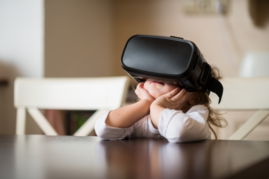 a little girl wearing a VR glass on a table